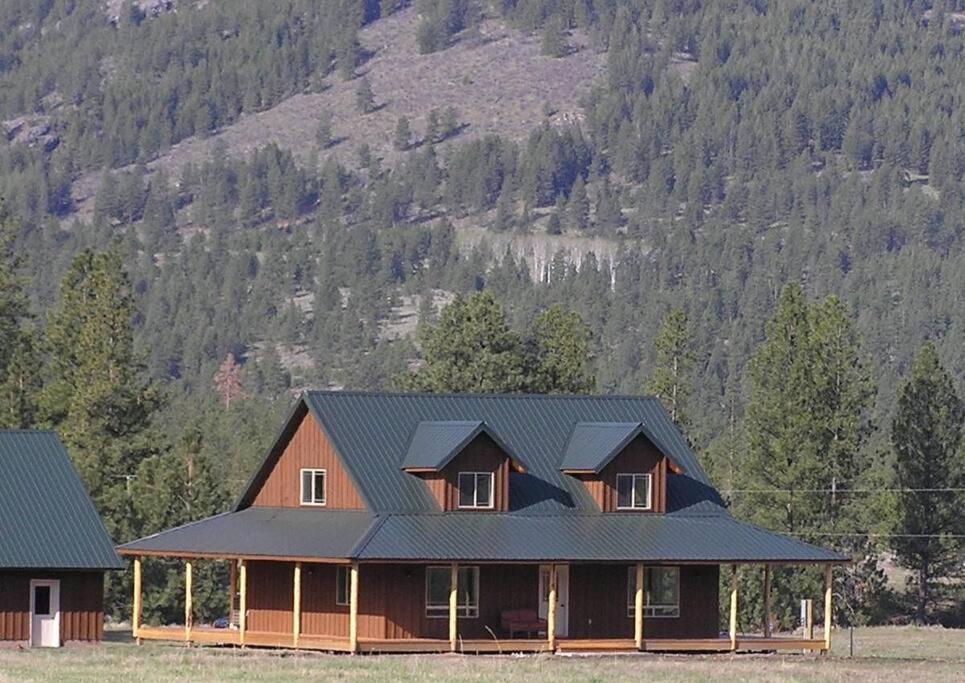 una casa con techo negro y montaña en Tunk Valley Ranch House, en Riverside