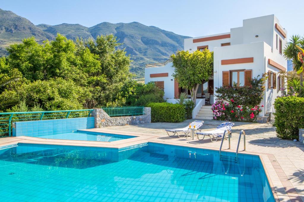 een villa met een zwembad en een huis bij Plakias Villas in Lefkogeia