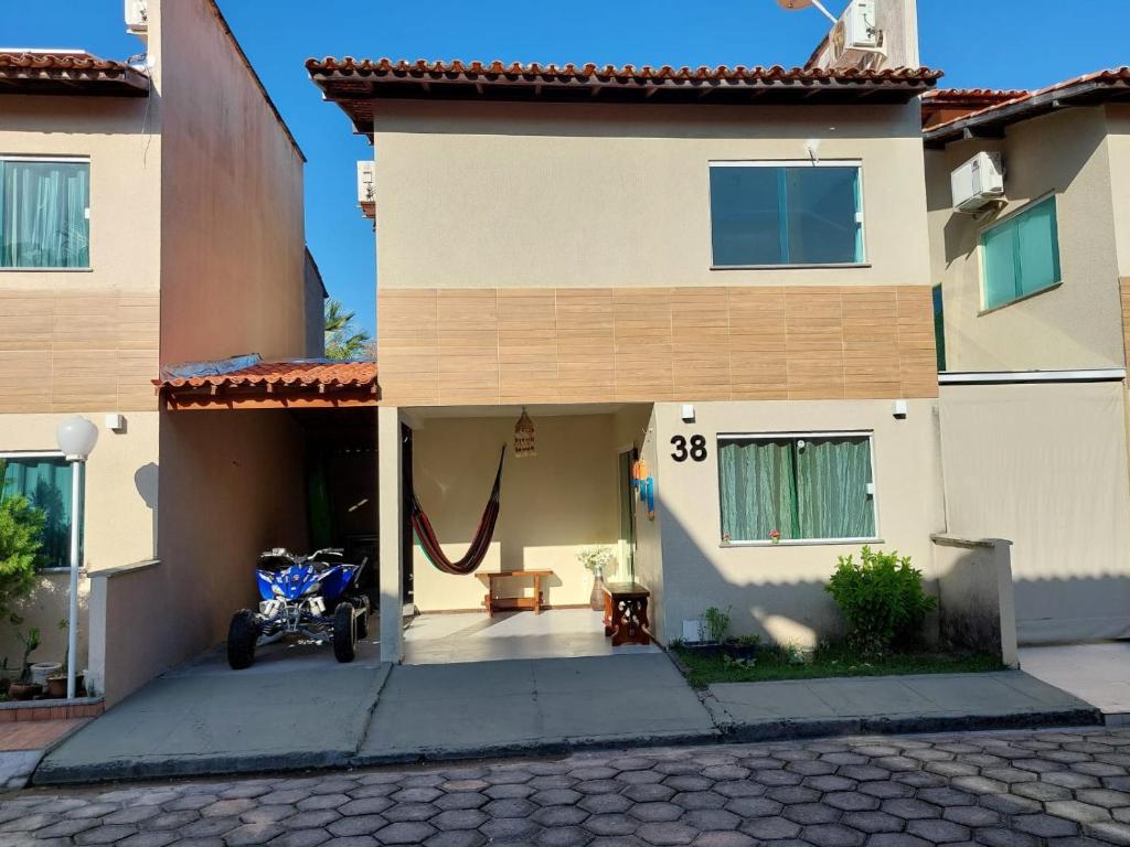 a house with a motorcycle parked outside of it at Lençóis Ville residence - Chalé 38 in Barreirinhas