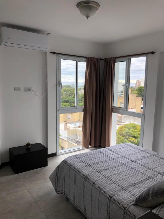 a bedroom with a bed and a large window at UBICACION IDEAL Centro de San Luis in San Luis