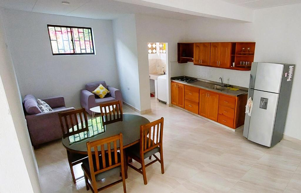 cocina y sala de estar con mesa y nevera en Habitación privada en Jericó 2_ La Gruta, en Jericó
