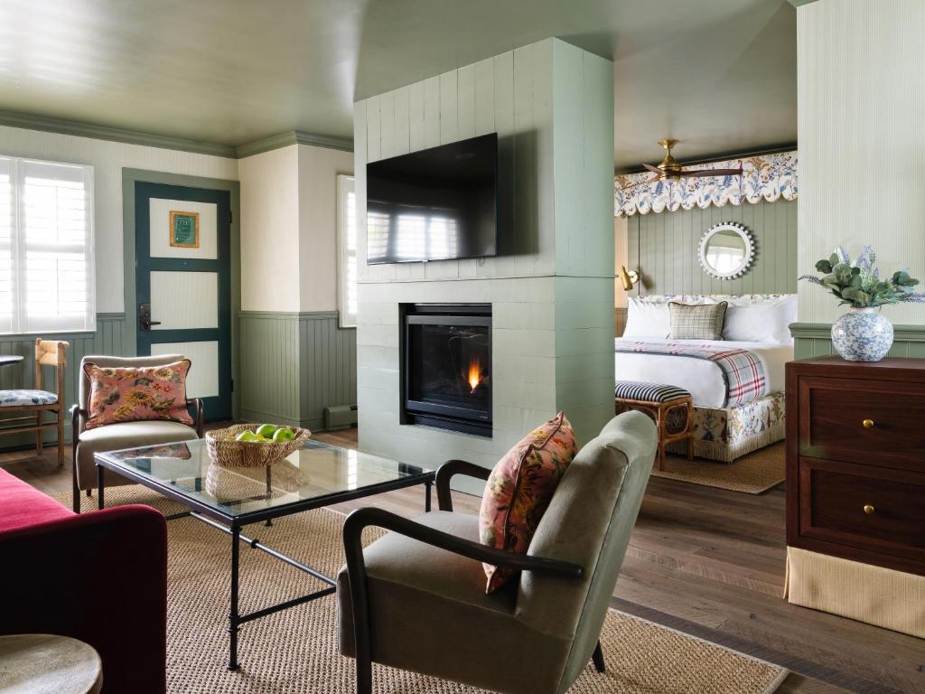 a living room with a fireplace and a bedroom at Le Petit Pali at 8th Ave in Carmel