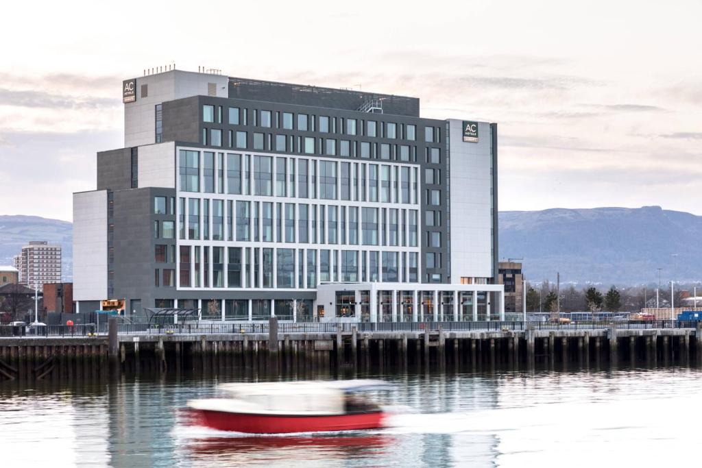 un barco en el agua frente a un edificio en AC Hotel by Marriott Belfast en Belfast