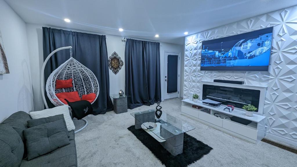 Konia Suites في أورنجفيل: غرفة معيشة مع أريكة وتلفزيون على الحائط
