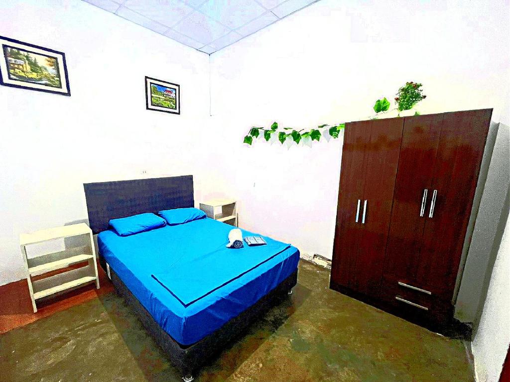 a bedroom with a blue bed and a cabinet at Cómoda y céntrica habitación en Iquitos in Iquitos