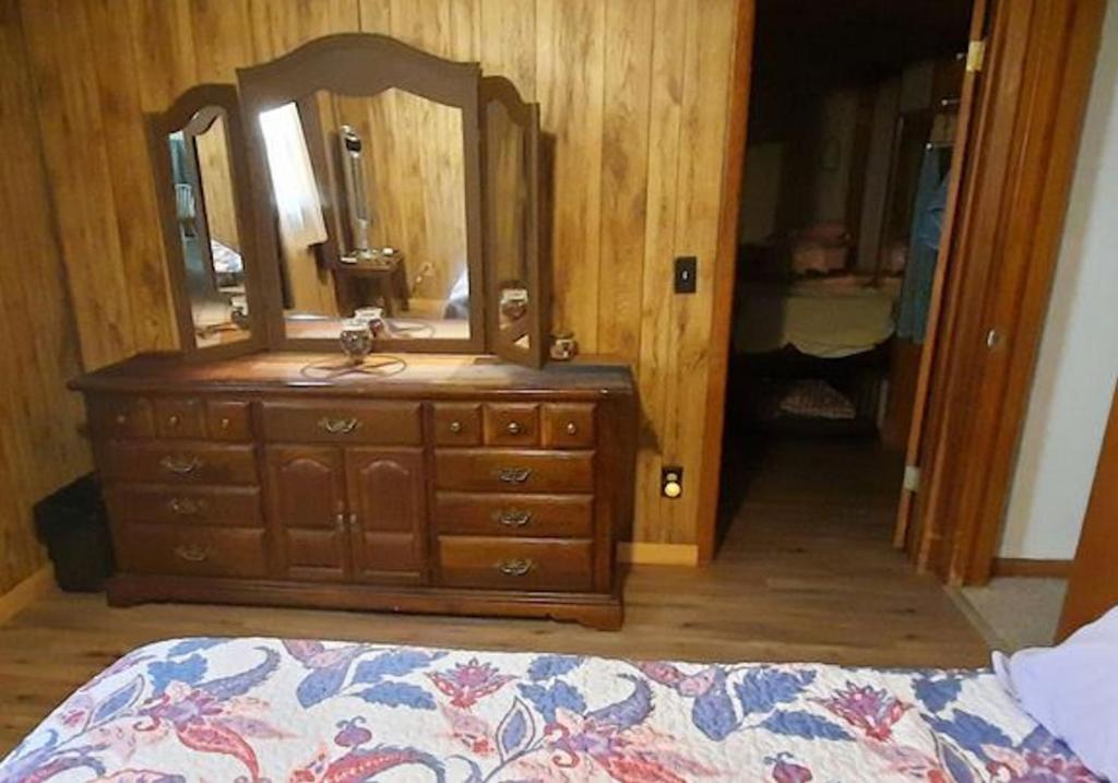 um quarto com uma cómoda com um espelho e uma cama em Sandie's Country Bed and Bath em Chiefland