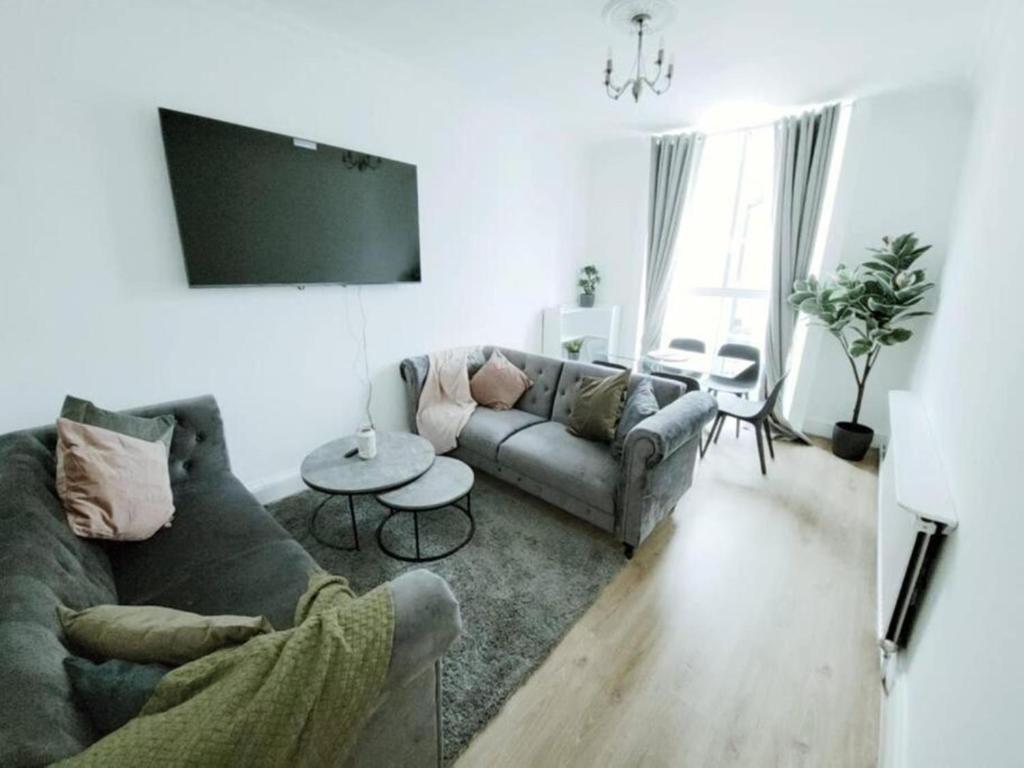 uma sala de estar com um sofá e uma mesa em Prime London Living 2-Bedroom Beauty! em Londres