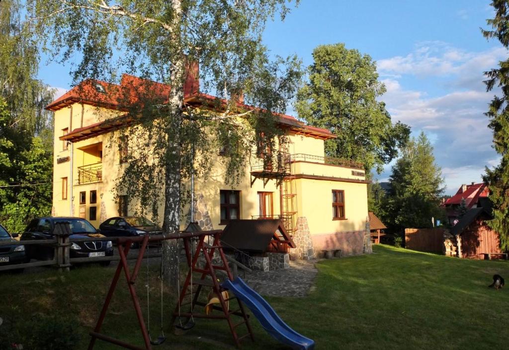 ein Haus mit einem Spielplatz davor in der Unterkunft Noclegi NADZAMCZE in Czorsztyn