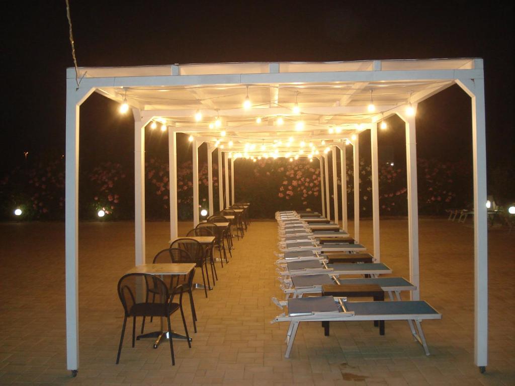 a row of tables and chairs under a pavilion with lights at Villa Lara in Polignano a Mare
