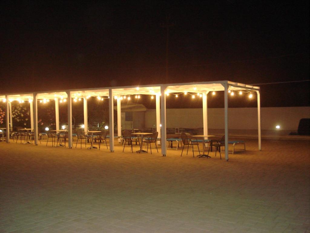 a group of tables and chairs under a pavilion at night at Villa Lara in Polignano a Mare