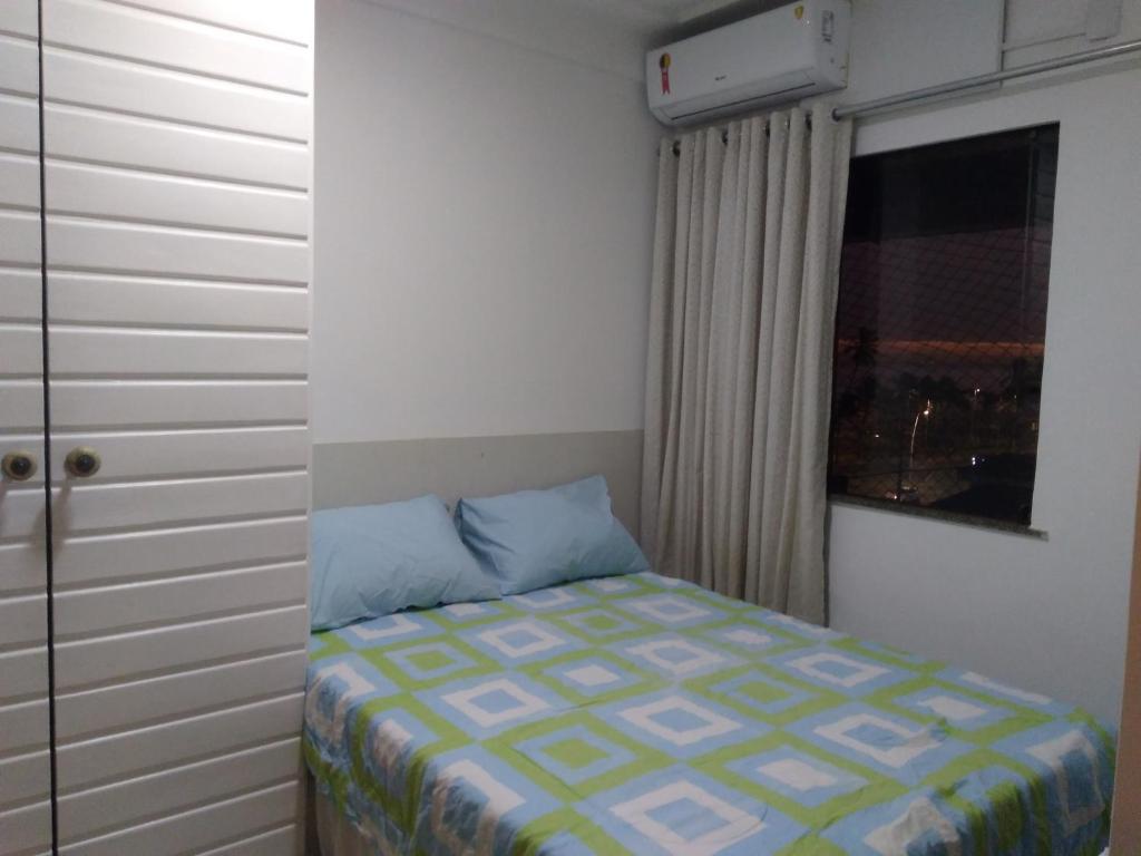 um pequeno quarto com uma cama e uma janela em Cobertura Duplex c/ Piscina em Salvador