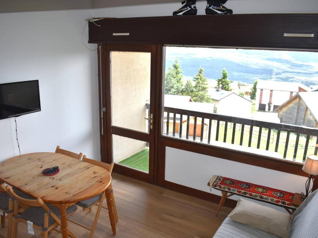 un salon avec une table et une grande fenêtre dans l'établissement Agréable studio mezzanine 3 couchages à Font-Romeu avec parking - FR-1-580-93, à Font-Romeu-Odeillo-Via