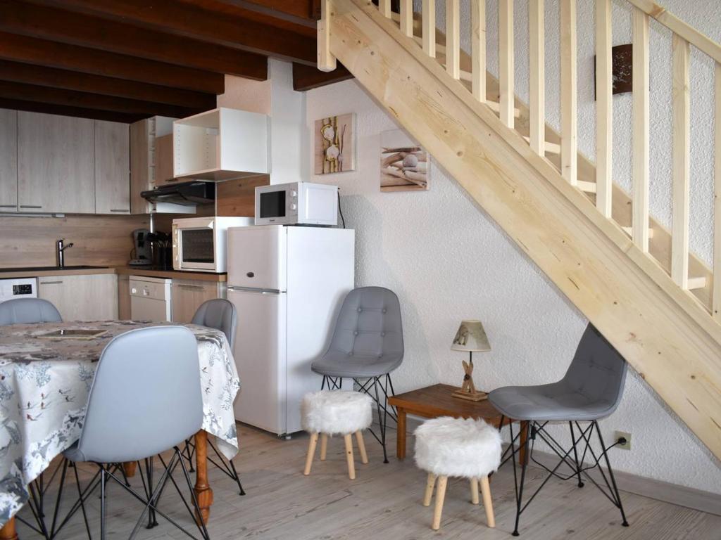 une cuisine avec une table et des chaises ainsi qu'un escalier dans l'établissement Appartement 3 Pièces avec Mezzanine, Balcon Sud, Parking et Cave - Centre Ville Proche Commodités - FR-1-580-92, à Font-Romeu-Odeillo-Via