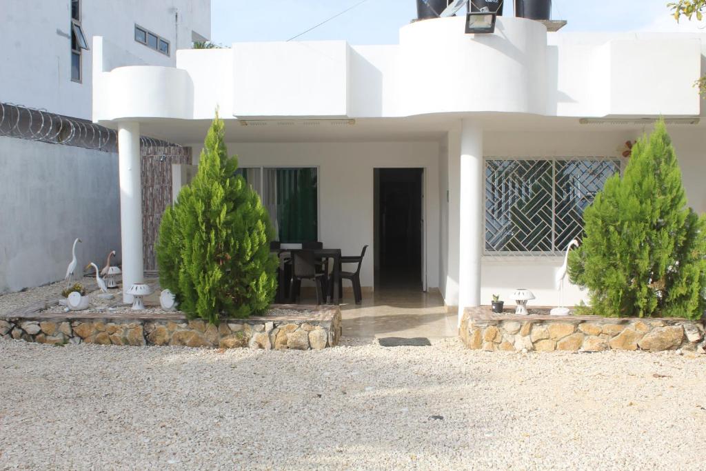 dom z dwoma choinkami przed nim w obiekcie CASAS BLANCAS Coveñas w mieście Coveñas