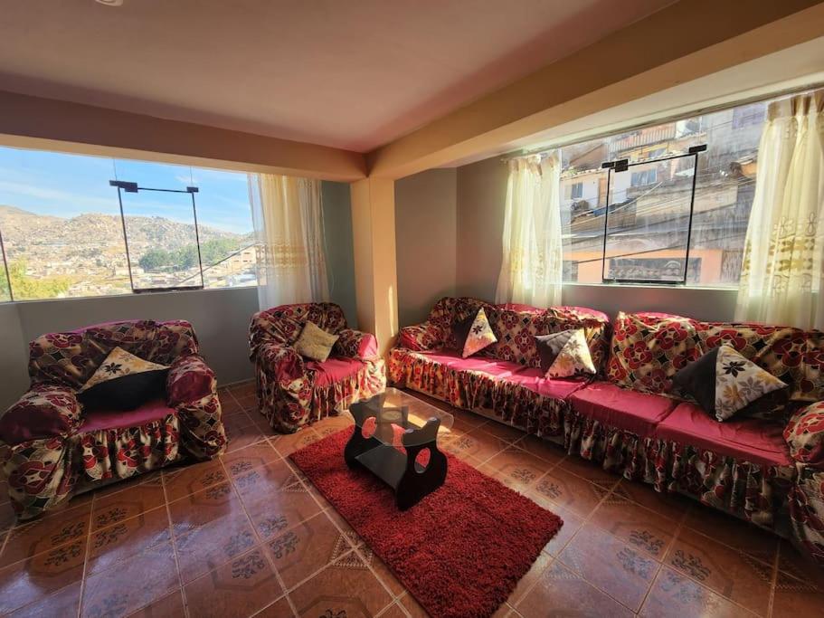 a living room with a red couch and two chairs at Casa Mirador SanBlas in Cusco