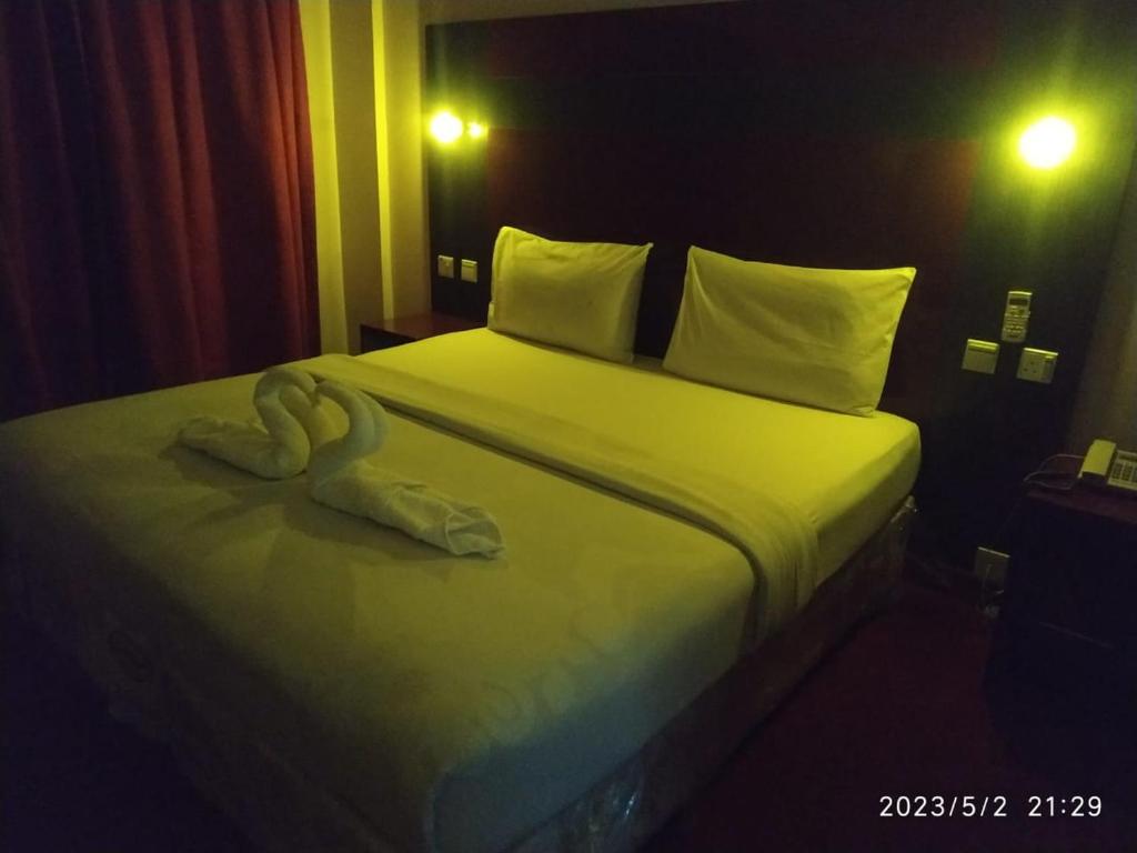 Un dormitorio con una cama con una toalla. en Tehran Hotel en Dubái