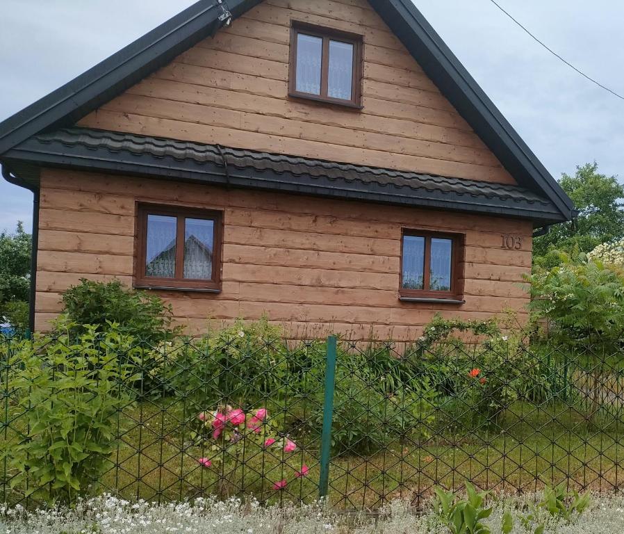 een huis met drie ramen en een hek bij Gosciniec in Kodeń