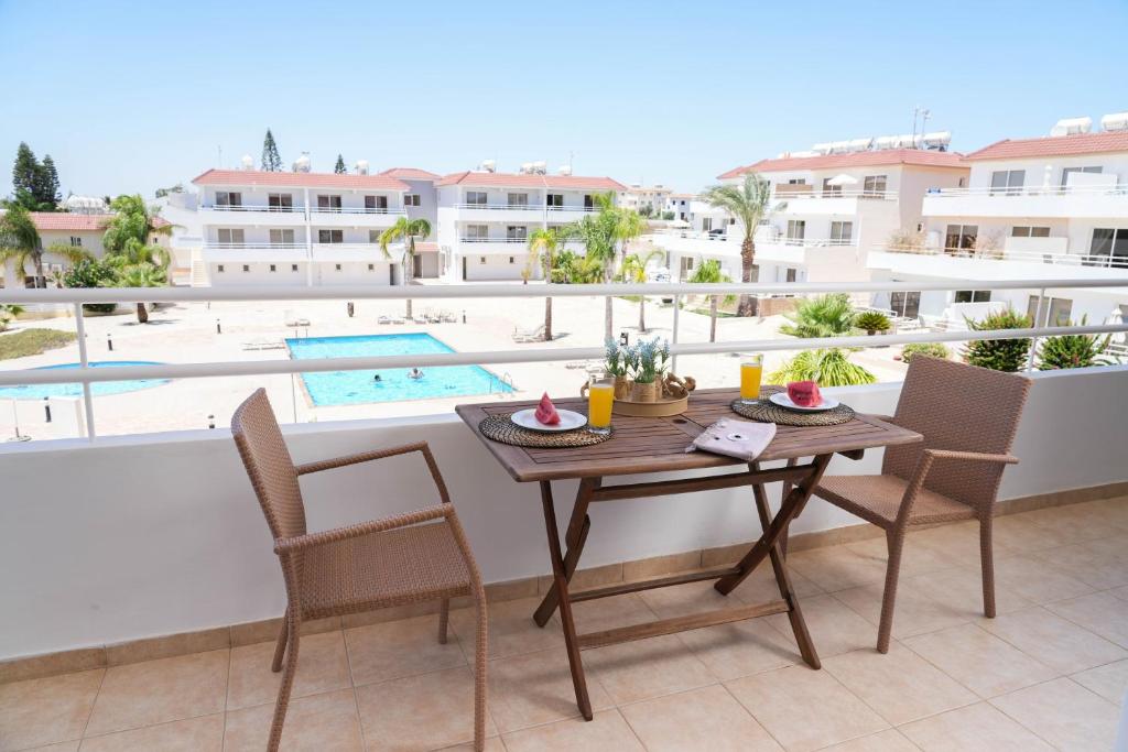 uma mesa e cadeiras na varanda de um apartamento em Narcissos 'Nissi Beach' Apartment E9 em Agia Napa