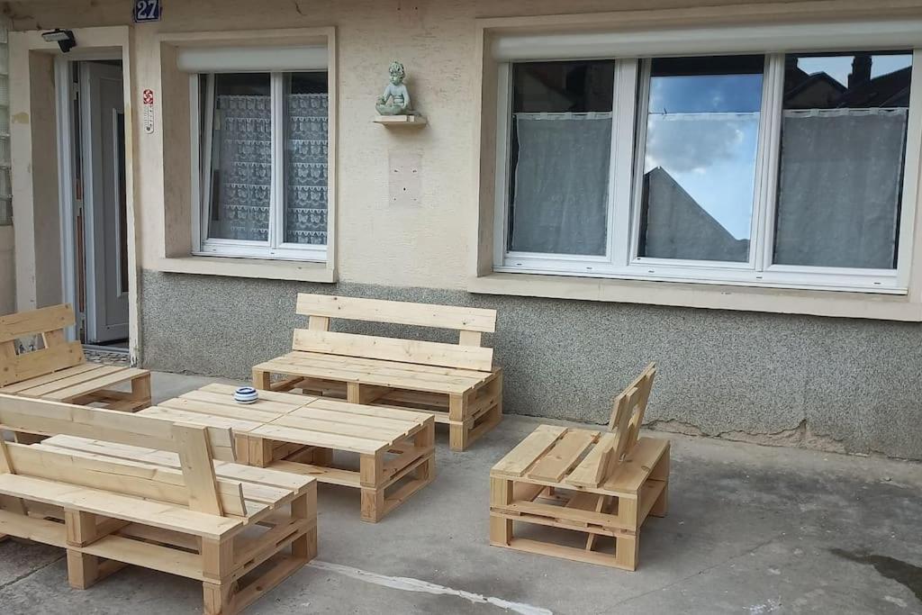 eine Gruppe von Holzbänken, die außerhalb eines Gebäudes sitzen in der Unterkunft Chez Malo 