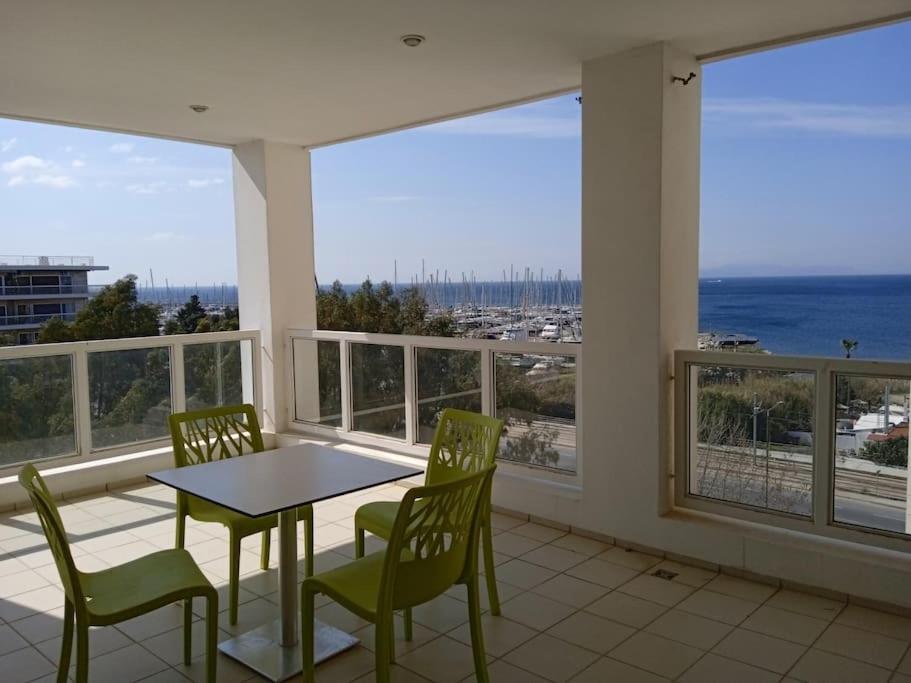 a balcony with a table and chairs and a view of the ocean at Eden Mare 6th Floor in Athens