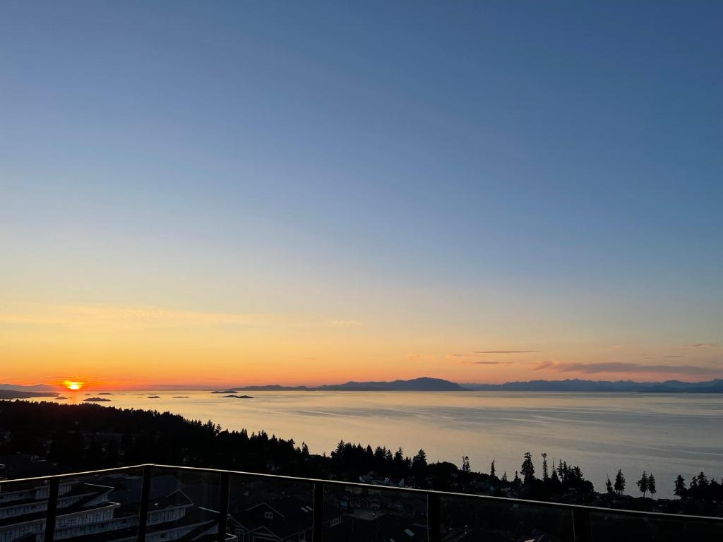a view of a sunset over a body of water at Auspicious Sea View House in Nanaimo