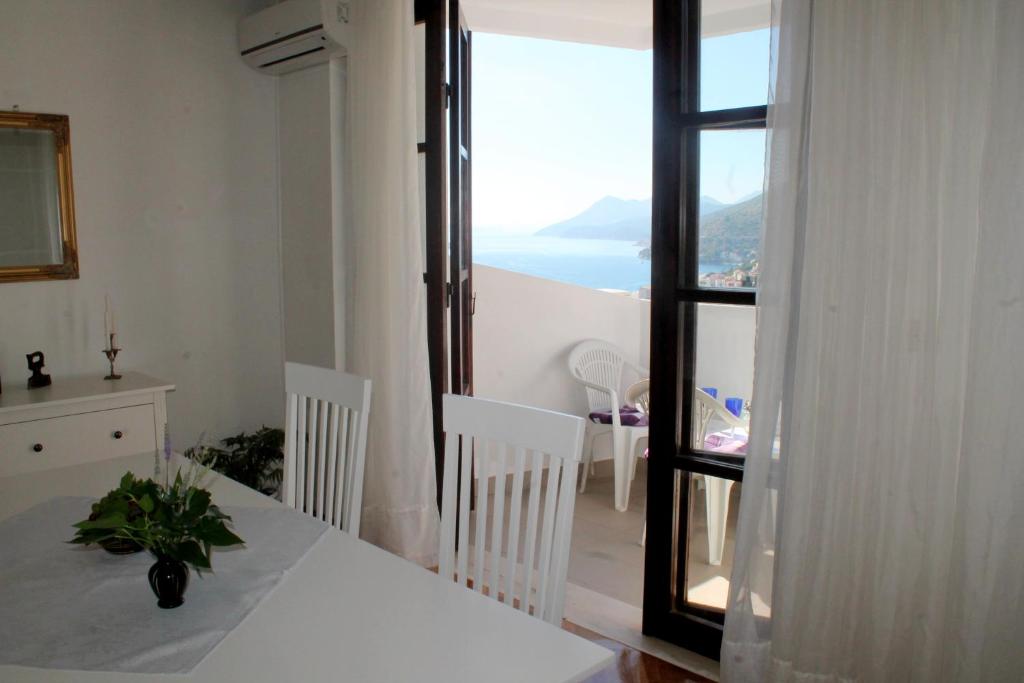 a white table and chairs in a room with a window at Apartment Anet with free parking in Dubrovnik