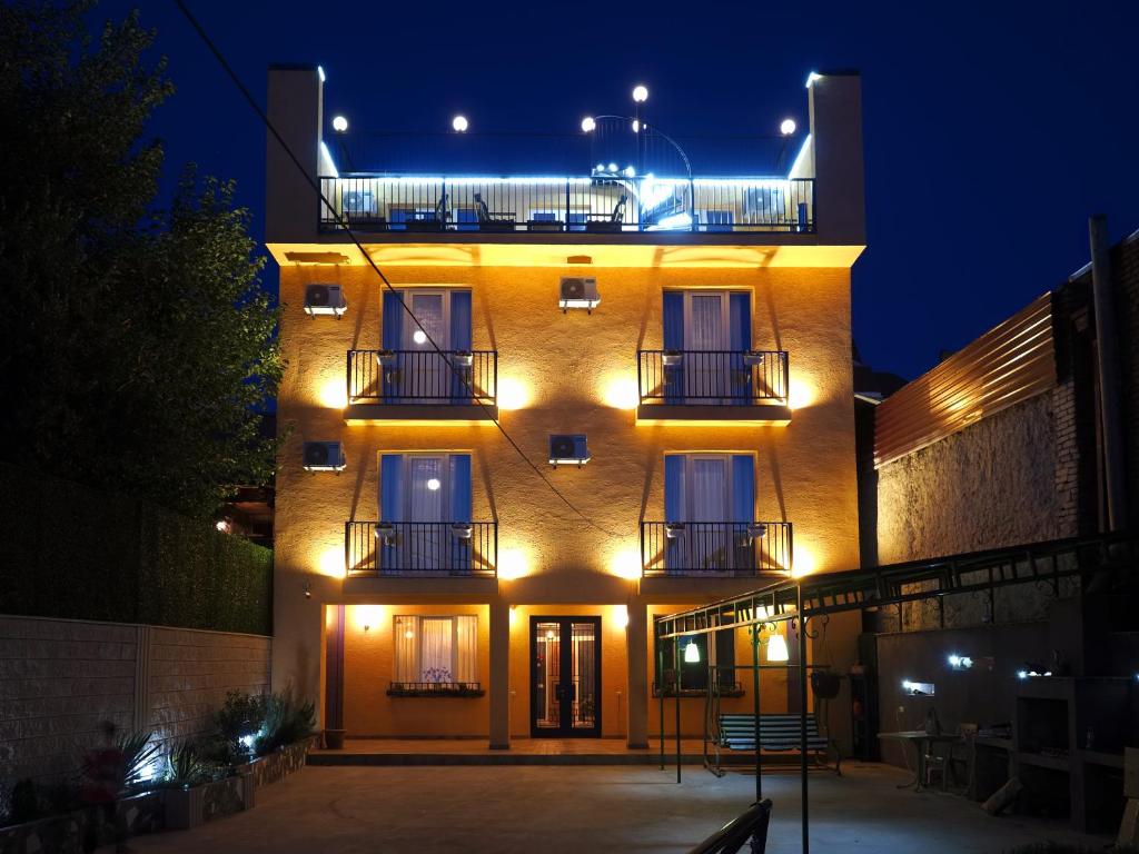 un bâtiment avec des lumières sur son côté la nuit dans l'établissement Hotel BaniHills Tbilisi, à Tbilissi