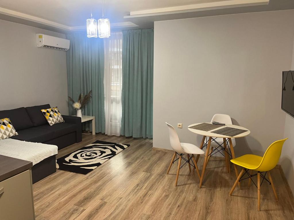 sala de estar con sofá, mesa y sillas en Guest House Amaya Med, en Plovdiv