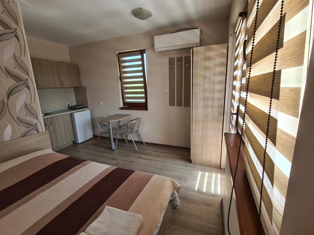 1 dormitorio con cama, mesa y cocina en House Varna-1, en Krapets