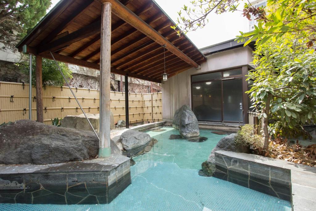 uma pequena piscina com pedras numa casa em Hotel Heian em Fuefuki