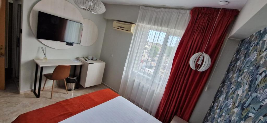 1 dormitorio con cama, escritorio y ventana en OITUZ Boutique Residence, en Mangalia