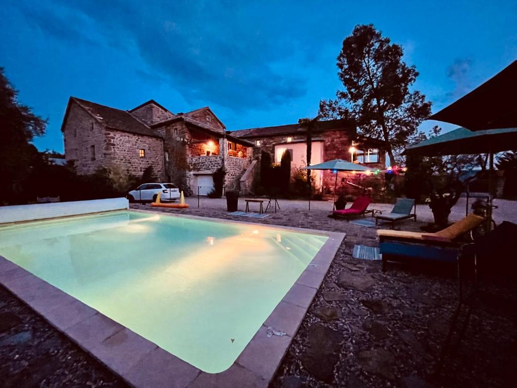 a swimming pool in front of a house at Le Planzollais in Planzolles