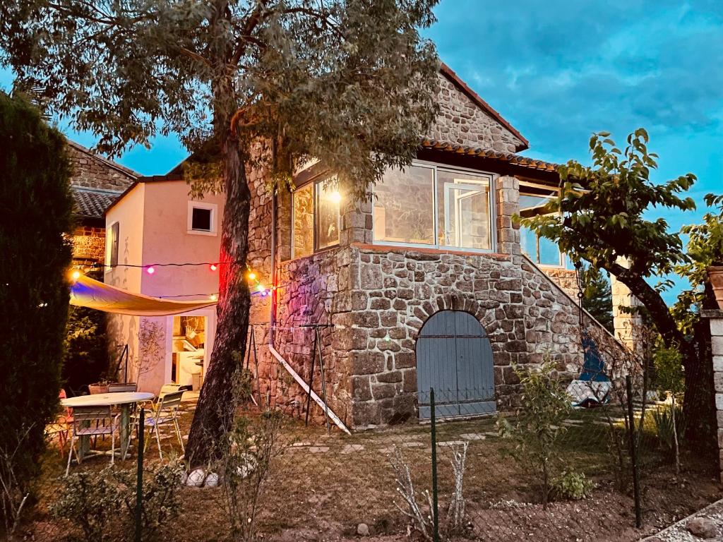 a house with a stone building with a door at Le Planzollais in Planzolles