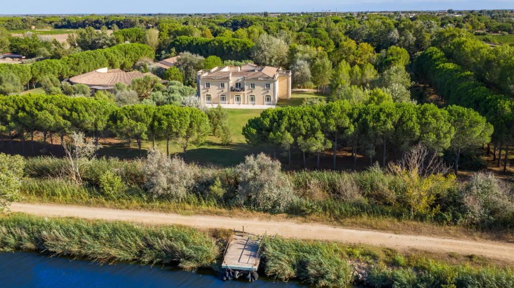 eine Luftansicht eines großen Hauses am Fluss in der Unterkunft Le Mas Des Sables in Aigues-Mortes