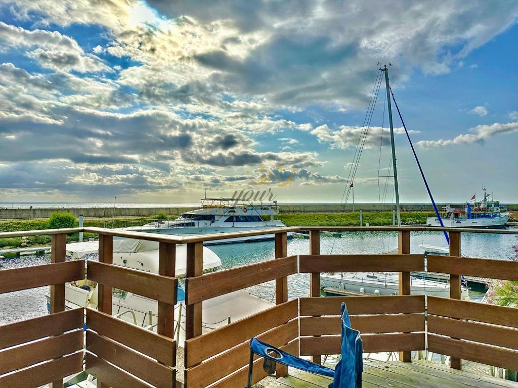 un bateau est amarré dans un port de plaisance avec deux bateaux dans l'établissement Le Yacht YourHostHelper, à Deauville