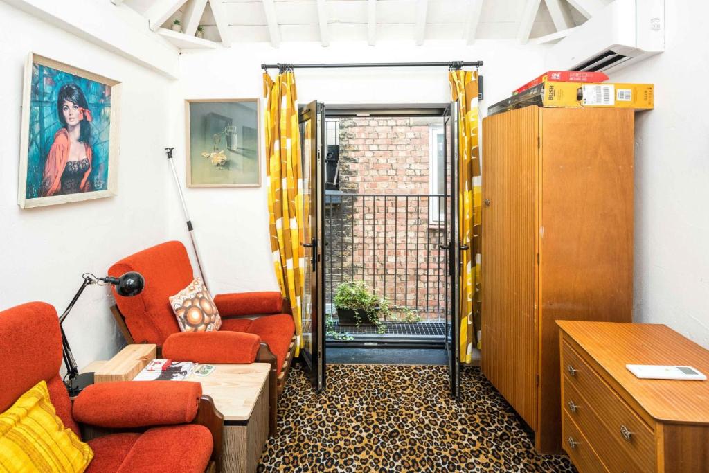 ロンドンにあるCUTE HOUSE IN SOHO - full ac, quiet and unique!のリビングルーム(オレンジの椅子2脚、テーブル付)