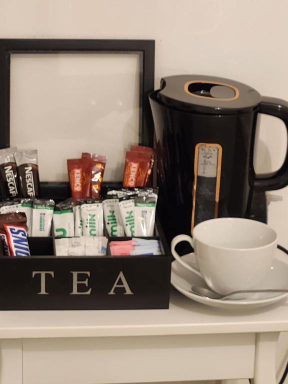 uma caixa de chá sentada numa mesa com uma chávena de café em Private luxurious space em Basildon