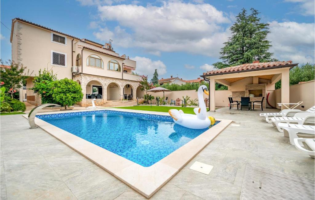 a swimming pool with a swan in a backyard at 2 Bedroom Nice Apartment In Medulin in Medulin