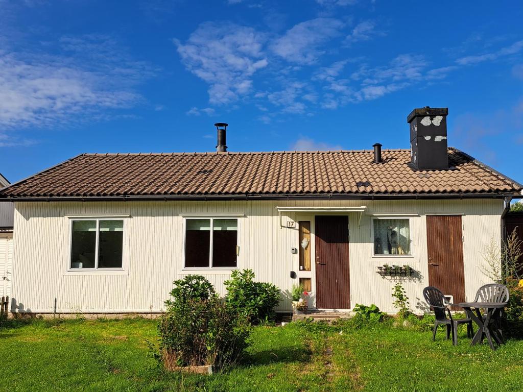 Cottage Halle-Hunneberg في Vargön: بيت ابيض وساعه بالسطح