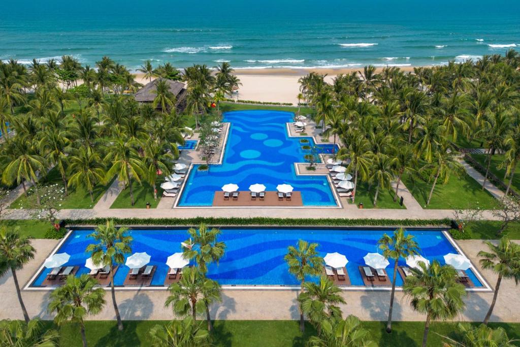 Two bright blue pools sit among palms between the resort and the sandy beach.