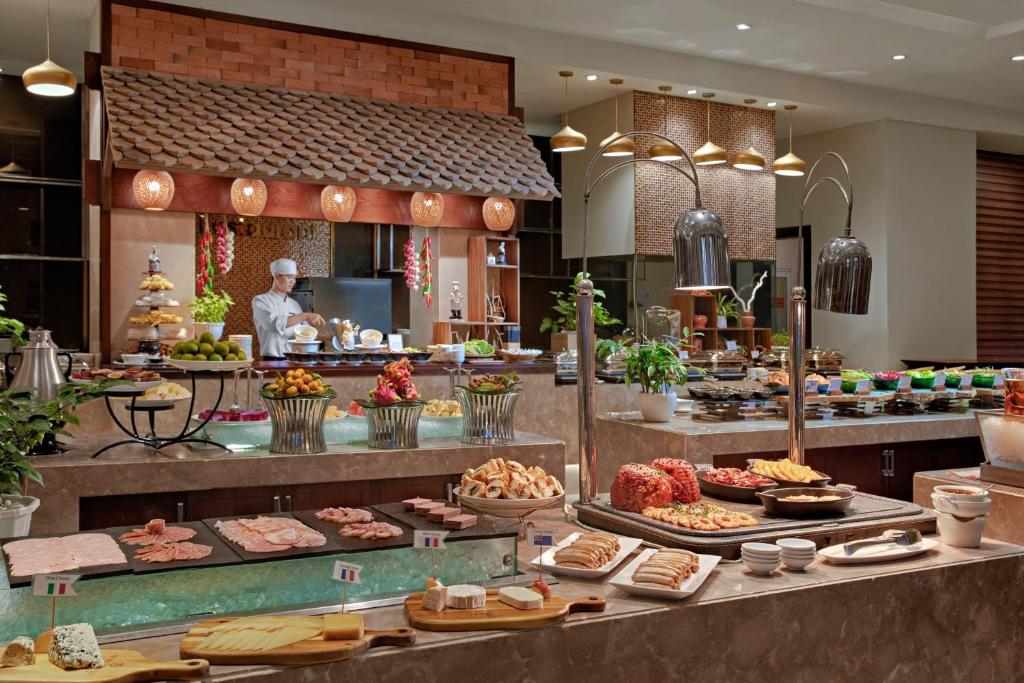 A large buffet display with breads, cold cuts, fruit and prepared dishes.