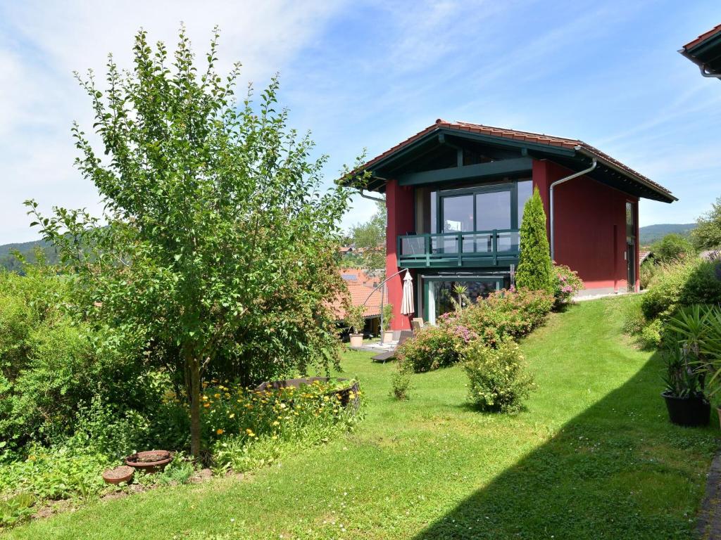 een huis met een groene tuin met een boom bij Tranquil Holiday Home in Blossersberg with Terrace in Viechtach
