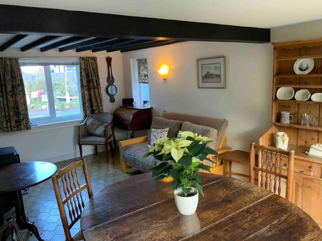 a living room with a table and a couch at Ivy cottage in West Mersea