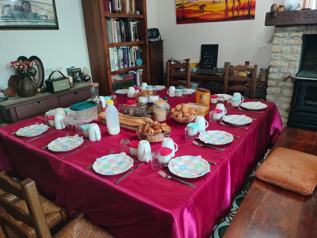 a table with a pink table cloth with food on it at Chez Aurélia - Chambres &amp; Table d&#39;hôtes in La Couture-Boussey