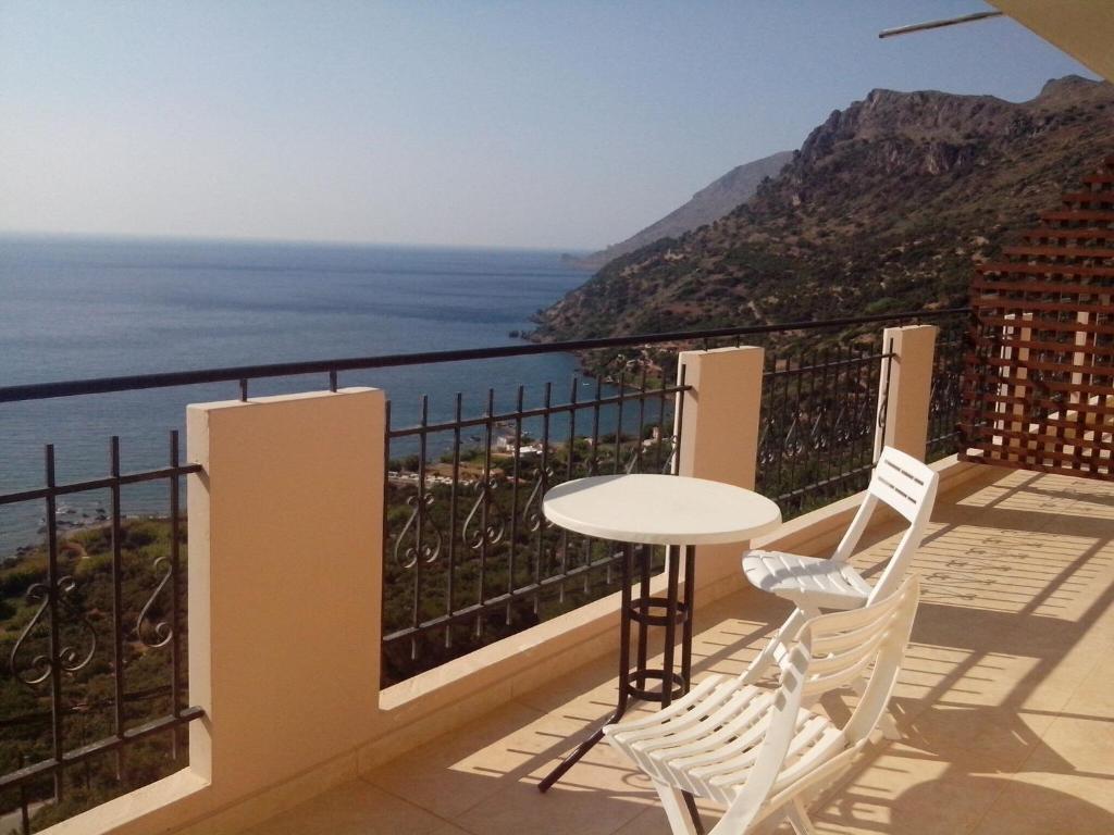 a balcony with a table and two chairs and the ocean at Seaview Studio in beautiful setting west from Chania in Ravdhoúkha