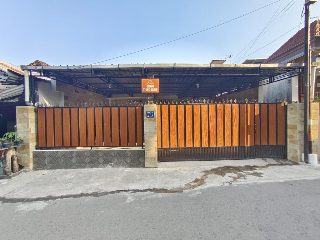 a wooden gate in front of a building at Griyo Mondoliko Homestay Jogja in Demangan