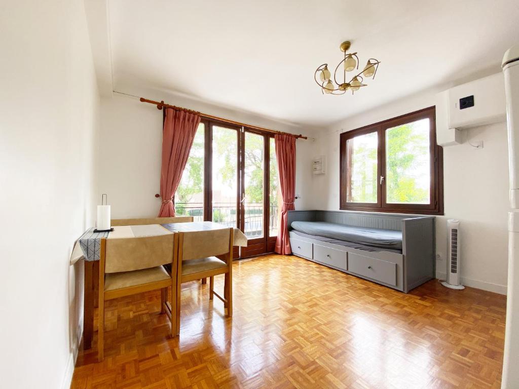 uma sala de estar com uma cama e uma mesa em T2 COSY * PARKING * WIFI * PARIS-DISNEY em Villiers-sur-Marne