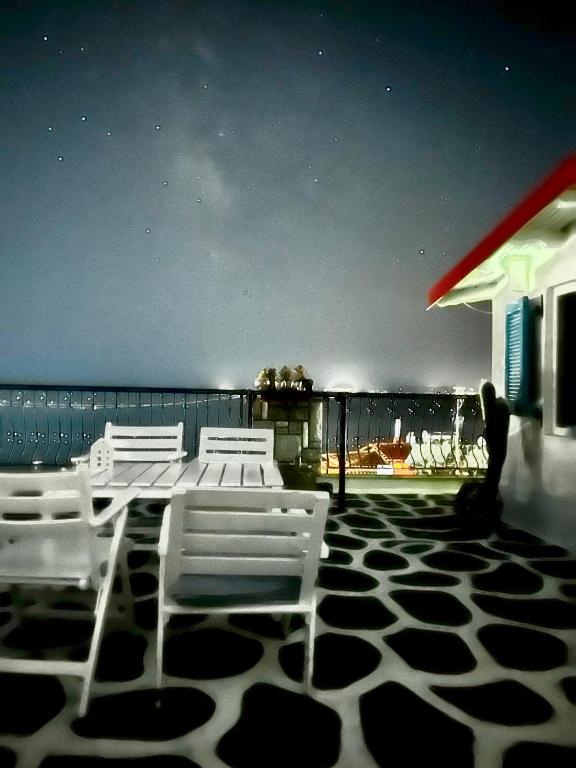 a table and chairs on a patio with a view of the ocean at Agape Studios in Neos Marmaras