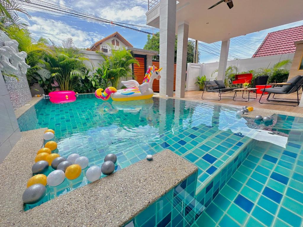 a swimming pool with a pool noodle in a house at Rosewood Pool Villa Pattaya 3 in Pattaya South