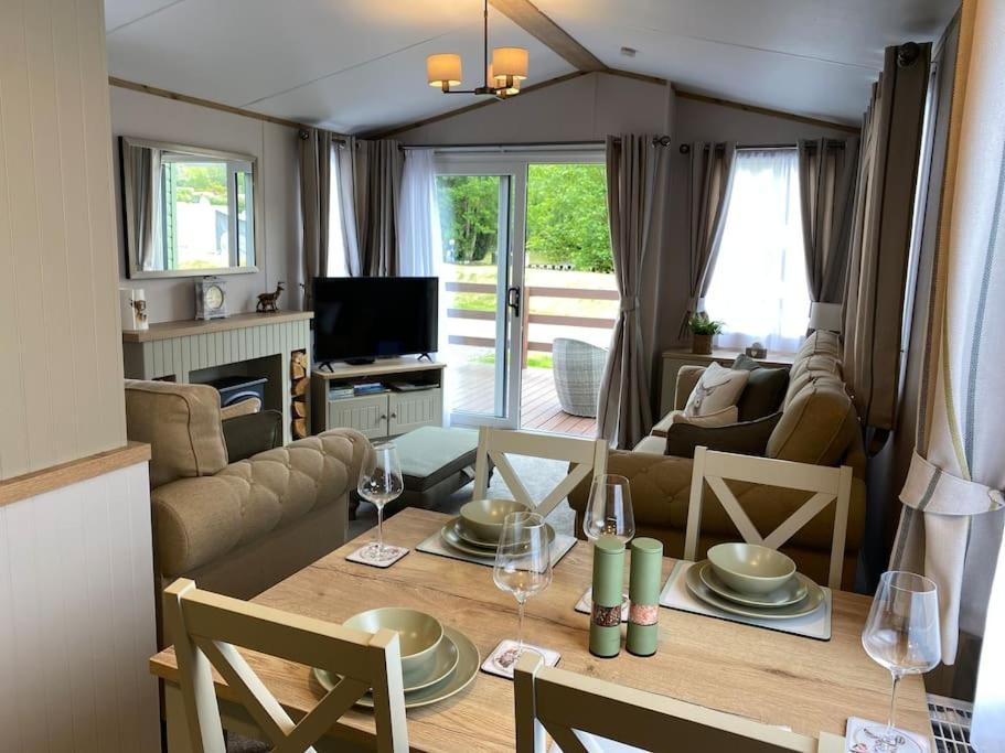 a living room with a table and a living room with a couch at Perfect for country lovers in Grantown on Spey